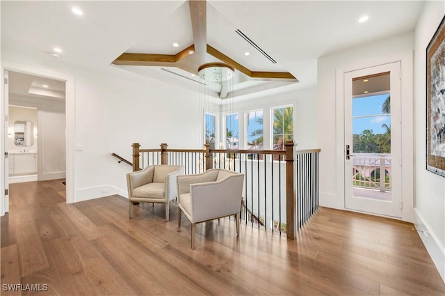 living area with wood finished floors, an upstairs landing, and recessed lighting