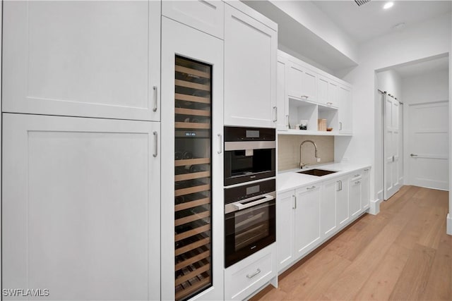 kitchen featuring light countertops, white cabinetry, a sink, and open shelves