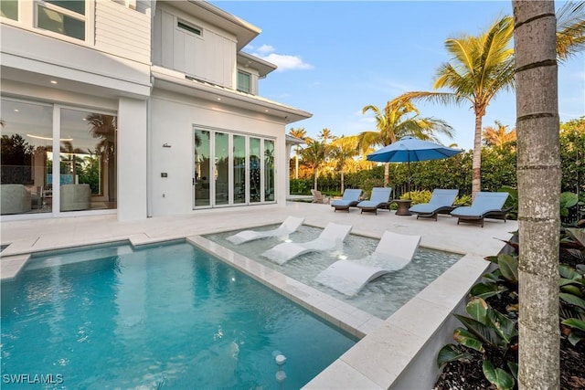 back of house featuring a fenced in pool, a patio area, and stucco siding