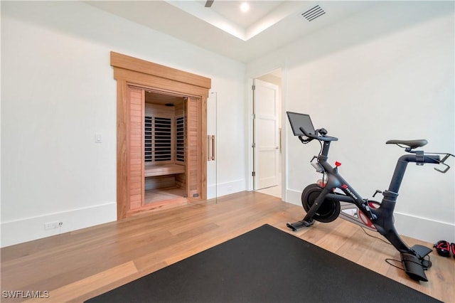 exercise area featuring visible vents, baseboards, and wood finished floors