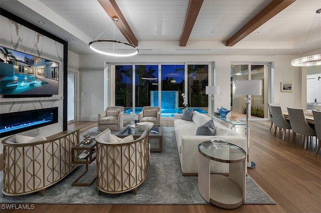 living area featuring a premium fireplace, wood finished floors, and beam ceiling