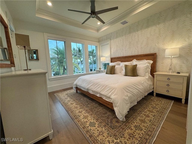 bedroom featuring recessed lighting, visible vents, baseboards, a raised ceiling, and wallpapered walls