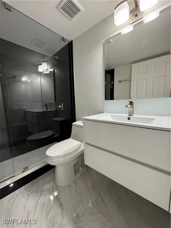 bathroom featuring vanity, an enclosed shower, and toilet