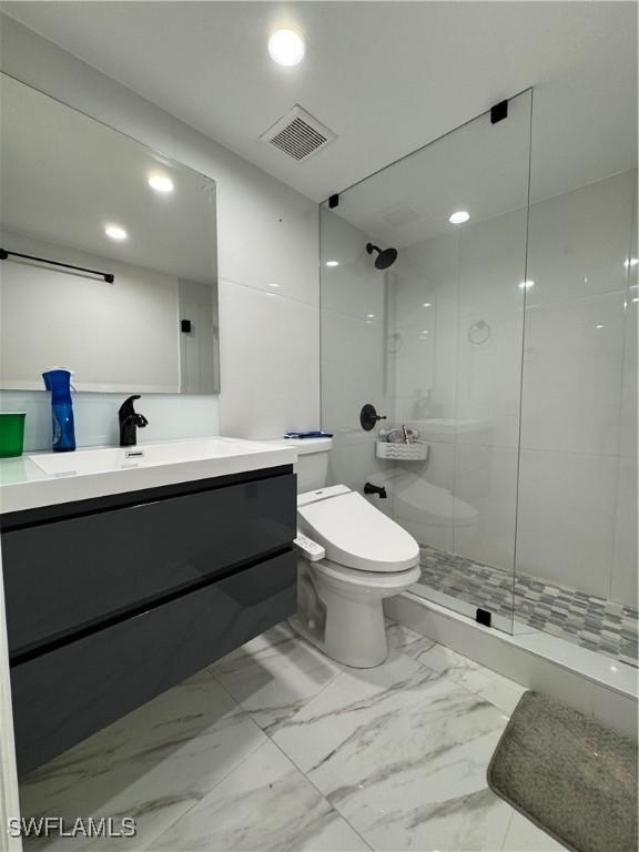 bathroom with an enclosed shower, vanity, and toilet