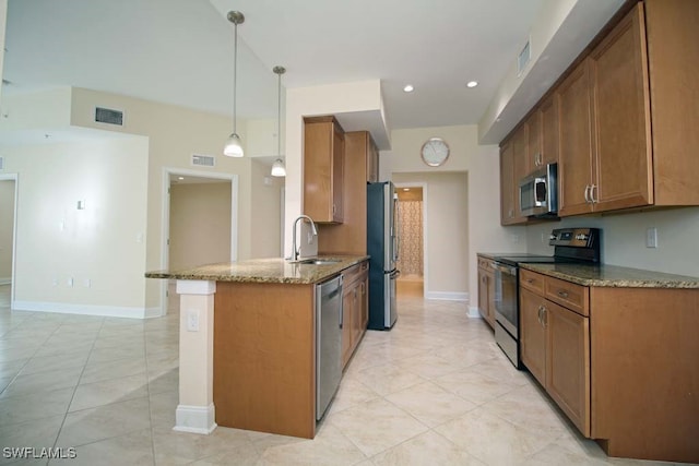 kitchen featuring pendant lighting, dark stone counters, sink, kitchen peninsula, and stainless steel appliances