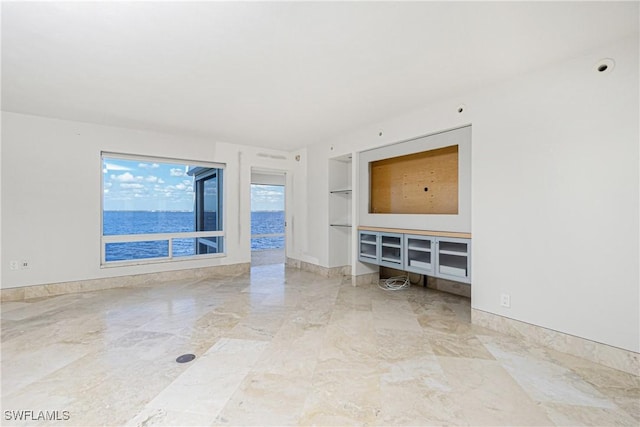 unfurnished living room featuring a water view