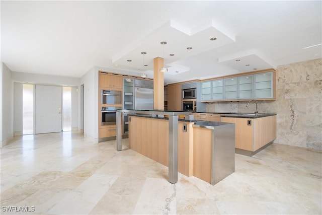 kitchen with light brown cabinets, sink, hanging light fixtures, built in appliances, and a kitchen island