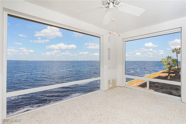 sunroom / solarium featuring ceiling fan and a water view