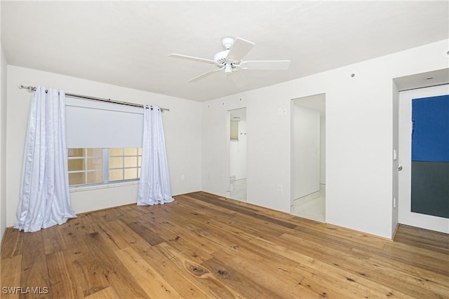 empty room featuring ceiling fan and light hardwood / wood-style flooring