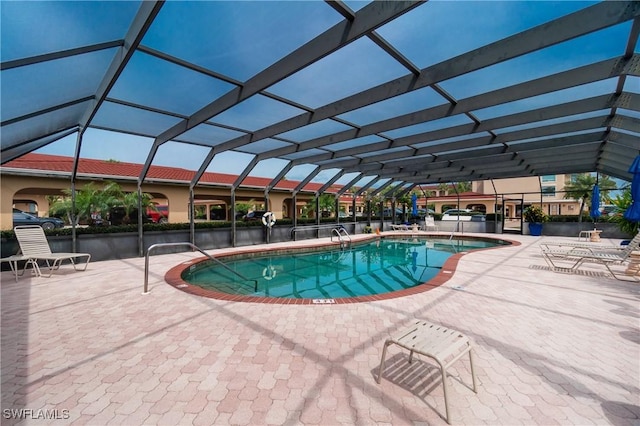 view of pool featuring glass enclosure and a patio area