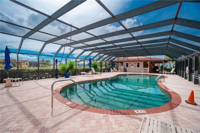 view of swimming pool with glass enclosure and a patio area