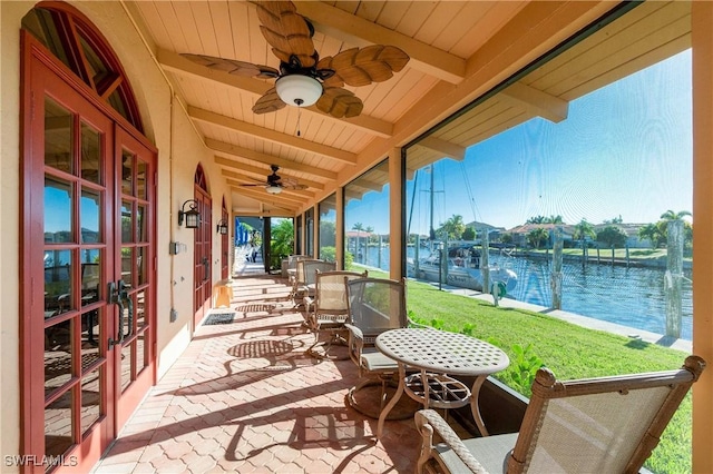 view of patio featuring ceiling fan, a water view, and french doors