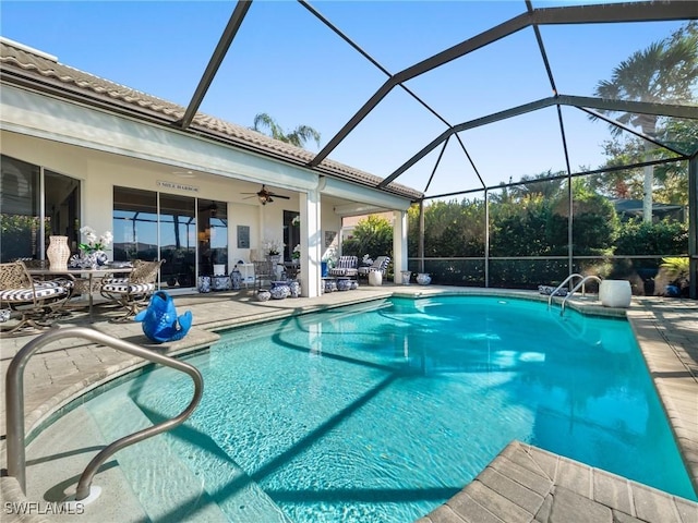 view of pool with glass enclosure, ceiling fan, and a patio