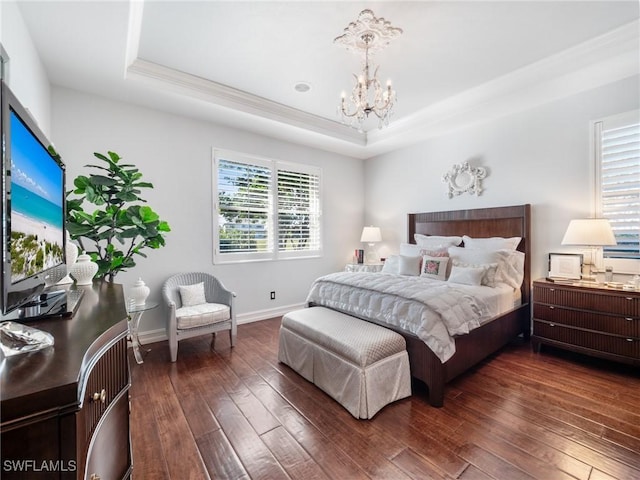 bedroom featuring a tray ceiling, an inviting chandelier, and dark wood-type flooring