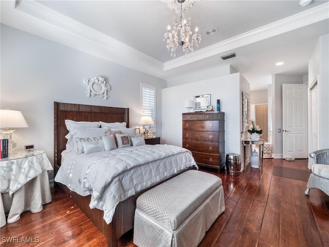 bedroom featuring a tray ceiling, crown molding, and dark wood-type flooring