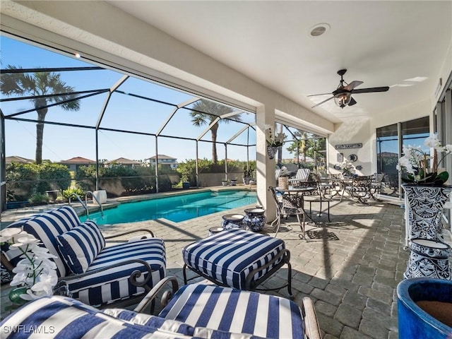 view of pool featuring a lanai, a patio area, ceiling fan, and an outdoor hangout area