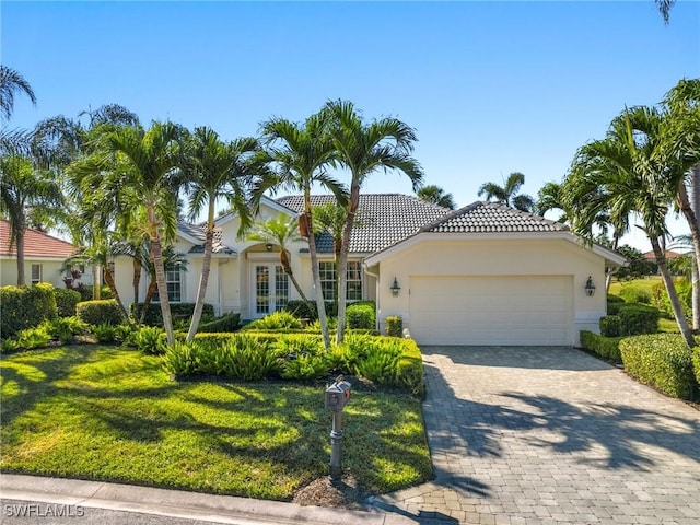 mediterranean / spanish house featuring a front lawn and a garage