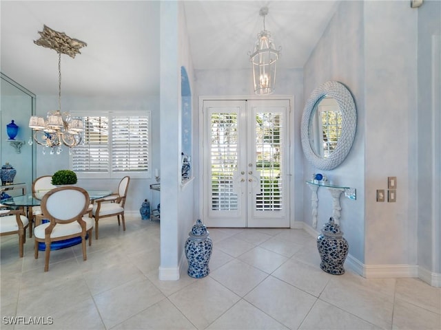 tiled entrance foyer with a notable chandelier and french doors