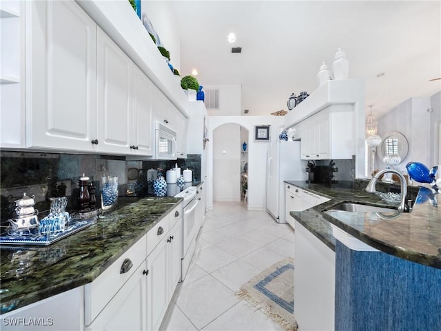 kitchen featuring white appliances, white cabinets, sink, light tile patterned floors, and tasteful backsplash