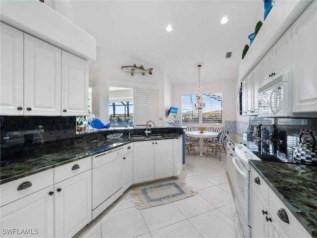 kitchen with backsplash, white appliances, pendant lighting, light tile patterned floors, and white cabinetry