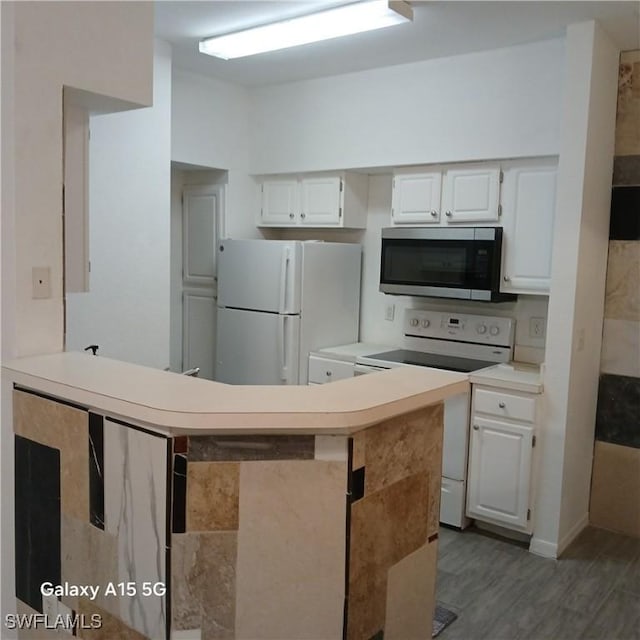 kitchen with kitchen peninsula, white cabinetry, dark hardwood / wood-style floors, and white appliances