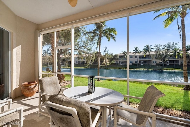 sunroom featuring a water view