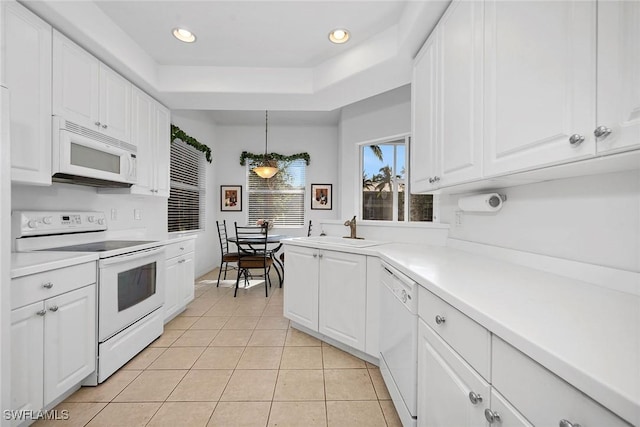 kitchen with white cabinets, white appliances, hanging light fixtures, and light tile patterned floors