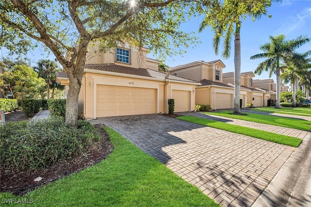 mediterranean / spanish-style home featuring a front yard and a garage