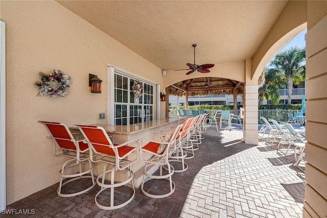 view of patio with ceiling fan and exterior bar