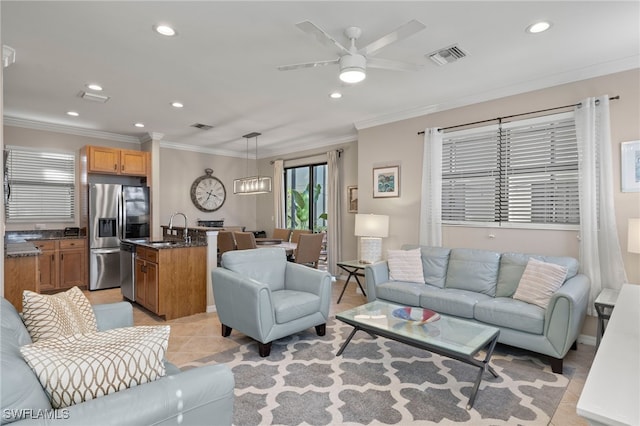 living room featuring crown molding, light tile patterned floors, sink, and ceiling fan with notable chandelier