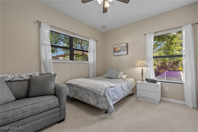 carpeted bedroom with ceiling fan and multiple windows