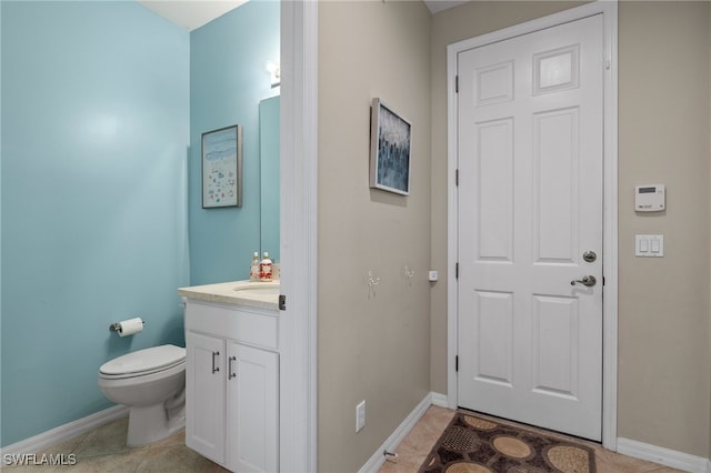 bathroom featuring tile patterned floors, vanity, and toilet