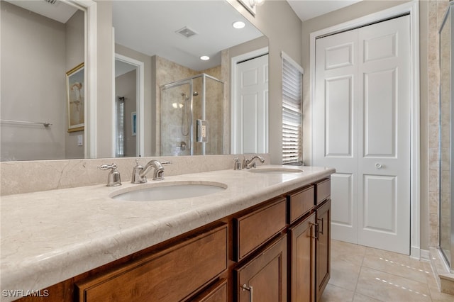 bathroom with an enclosed shower, vanity, and tile patterned flooring