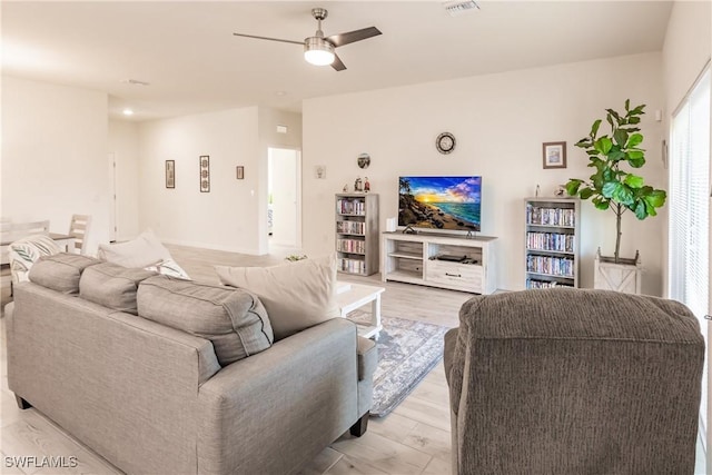 living area featuring light wood finished floors, visible vents, and a ceiling fan