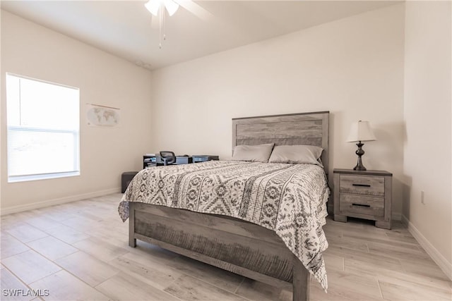 bedroom with light wood-style floors, ceiling fan, and baseboards