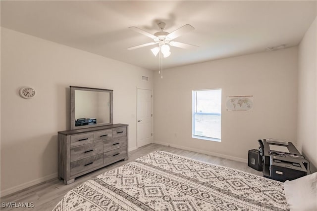 bedroom featuring baseboards, ceiling fan, visible vents, and light wood-style floors