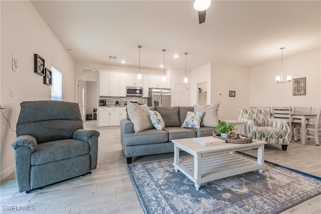 living area featuring light wood-style floors, recessed lighting, visible vents, and an inviting chandelier