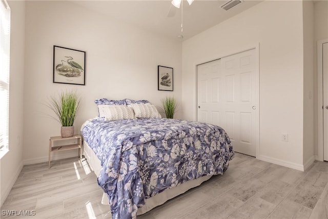 bedroom with light wood-style flooring, visible vents, and baseboards