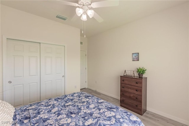 bedroom featuring a closet, visible vents, baseboards, and light wood finished floors