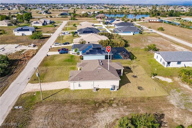 drone / aerial view with a water view and a residential view