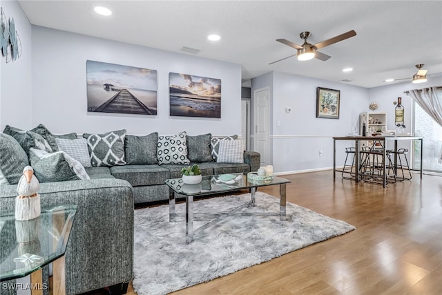 living room featuring ceiling fan and wood-type flooring