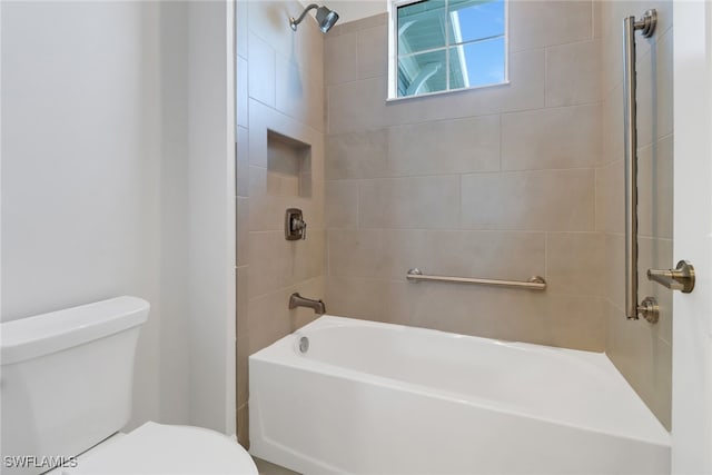 bathroom with tiled shower / bath combo and toilet