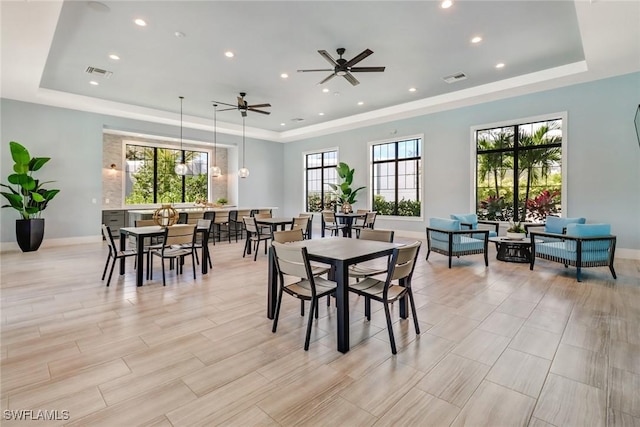 dining area with a raised ceiling, ceiling fan, plenty of natural light, and light hardwood / wood-style floors