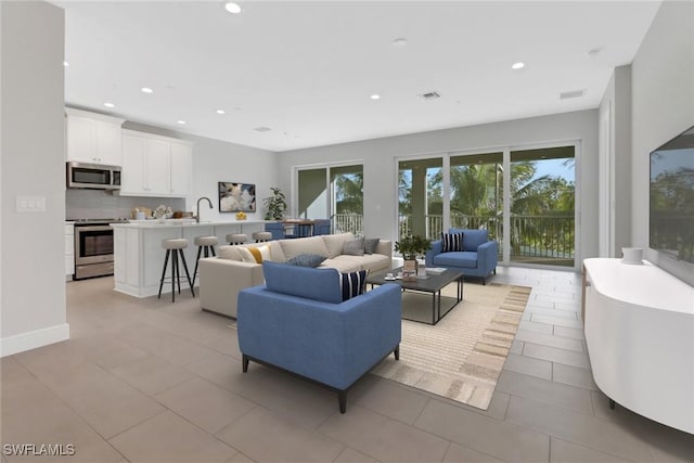 living room with light tile patterned floors and sink