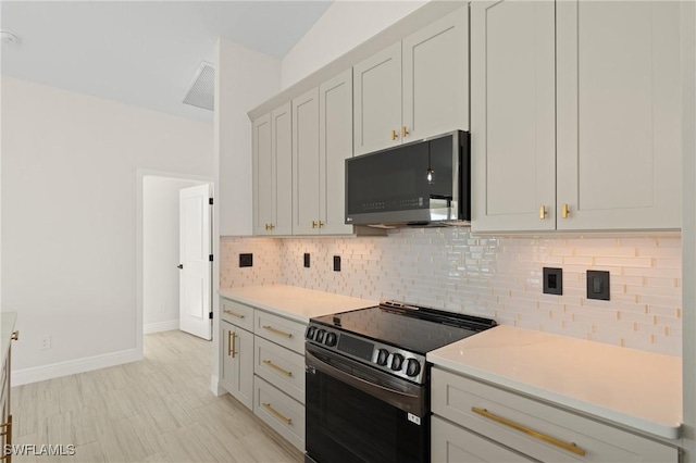 kitchen featuring tasteful backsplash, white cabinets, and electric range