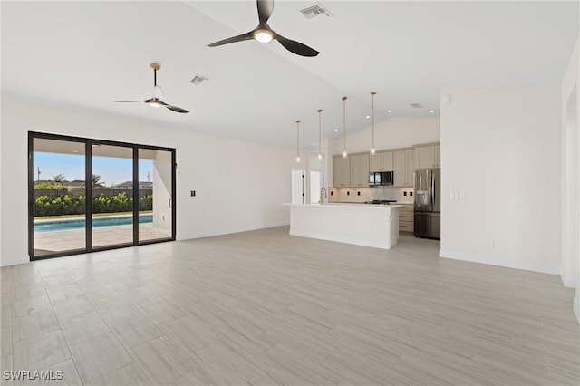 unfurnished living room with ceiling fan, sink, and vaulted ceiling