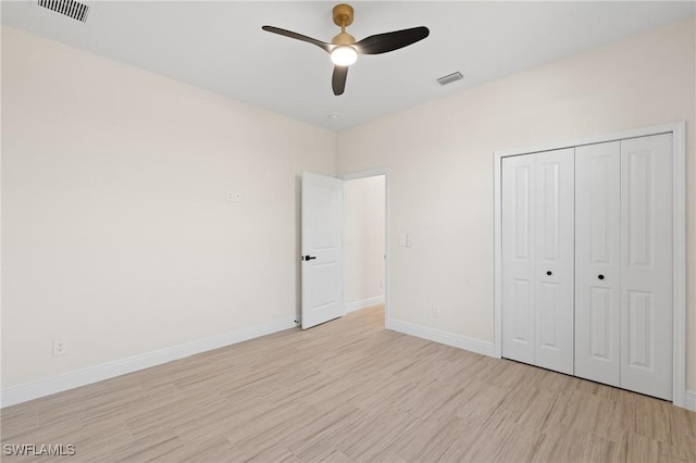 unfurnished bedroom featuring ceiling fan, a closet, and light wood-type flooring