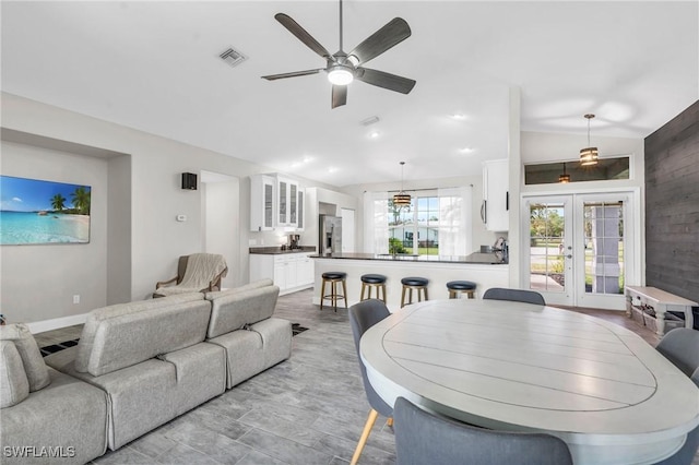 living area featuring visible vents, baseboards, a ceiling fan, french doors, and lofted ceiling
