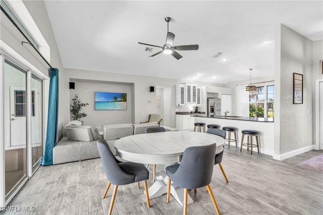 dining area featuring a ceiling fan, visible vents, light wood-type flooring, and baseboards