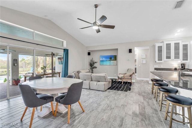 dining space featuring vaulted ceiling, ceiling fan, and light hardwood / wood-style floors